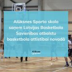 Basketbola laukums ar spēlētājiem, virs kura ir uzklāts zils pārklājums ar tekstu: "Alūksnes Sporta skola saņem Latvijas Basketbola Savienības atbalstu basketbola attīstībai novadā". Redzams arī logo "Alūksne".