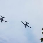Divi tumši militārie droni lido mākoņainās debesīs