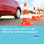 Sarkana automašīna uz asfalta ceļa, blakus virknē izvietoti oranži-balti satiksmes konusi. Attēla apakšdaļā uz gaiši zila fona balts teksts: "Pasākuma norises laikā 29. maijā Alūksnē būs satiksmes ierobežojumi" un Alūksnes novada logo.