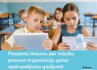 Divi bērni sēž klasē un koncentrēti skatās savos planšetdatoros. Attēlā redzamais teksts: Pieņemts lēmums par mācību procesa organizāciju gaisa apdraudējuma gadījumā. Alūksne Oinkaua.