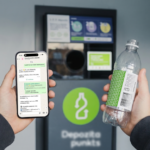 Personas rokas tuvplānā tur viedtālruni un tukšu plastmasas pudeli ar zaļu etiķeti. Viedtālruņa ekrānā redzams ziņojumapmaiņas logs ar virsrakstu "Depozīta punkta asistents". Sarunā jautāts "Sveiki! Kur var nodot iepakojumu?" un atbilde ir "Es esmu Depozīta punkts virtuālais asistents." ar iespējām, piemēram, "Tuvākais taromāts". Fonā atrodas depozīta automāts ar zaļu pudeles simbola logotipu un uzrakstu "Depozīta punkts".