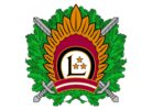 Latvijas militārā emblēma, kas attēlo zaļu ozollapu vainagu, krustotus sudraba zobenus un zeltainus saules starus. Centrālajā bordo aplī ir balts burts "L" ar trim zelta zvaigznēm, zem tā – stilizēta Latvijas karoga krāsu lenta.